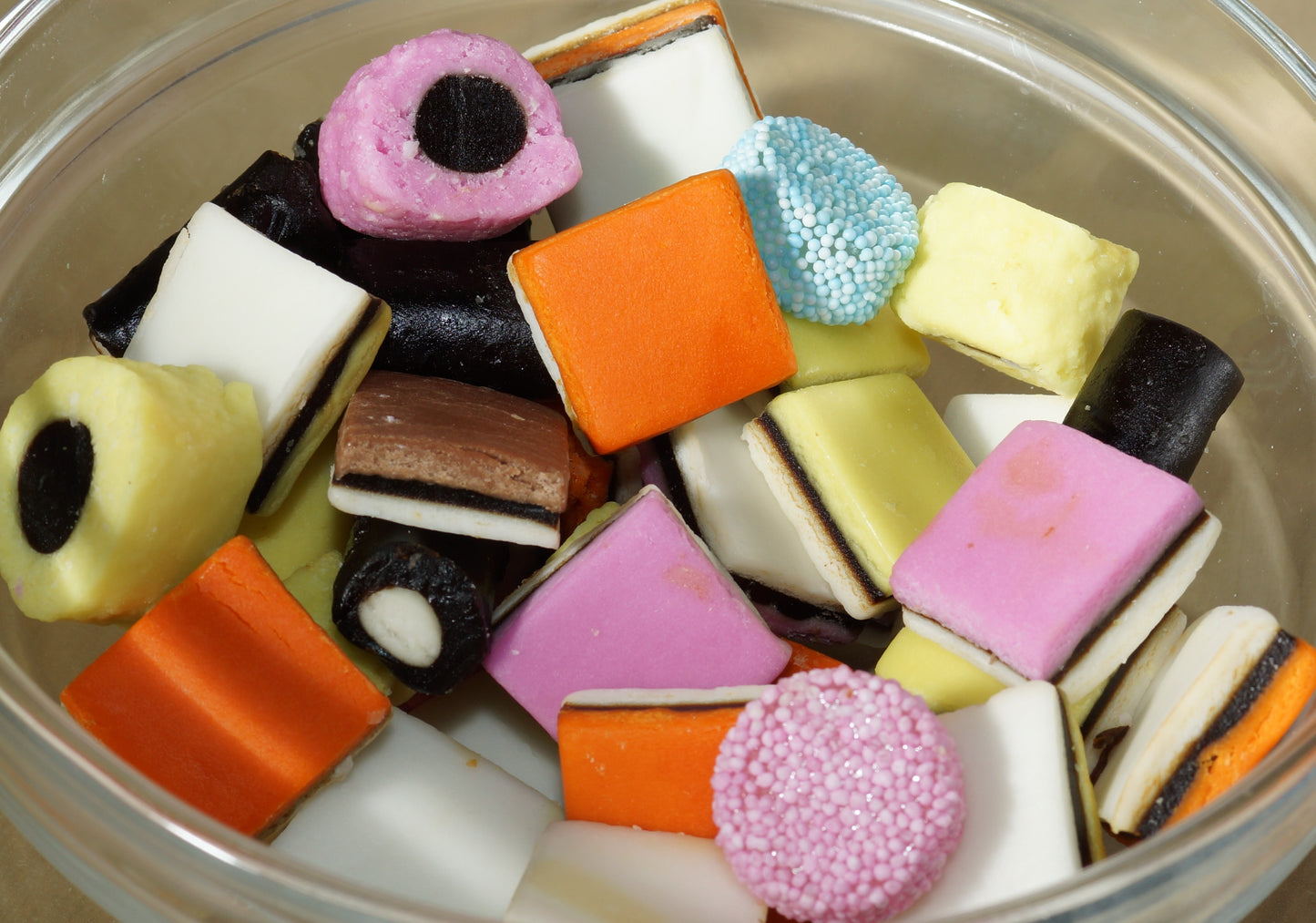 Assorted colorful hard candies in a clear bowl