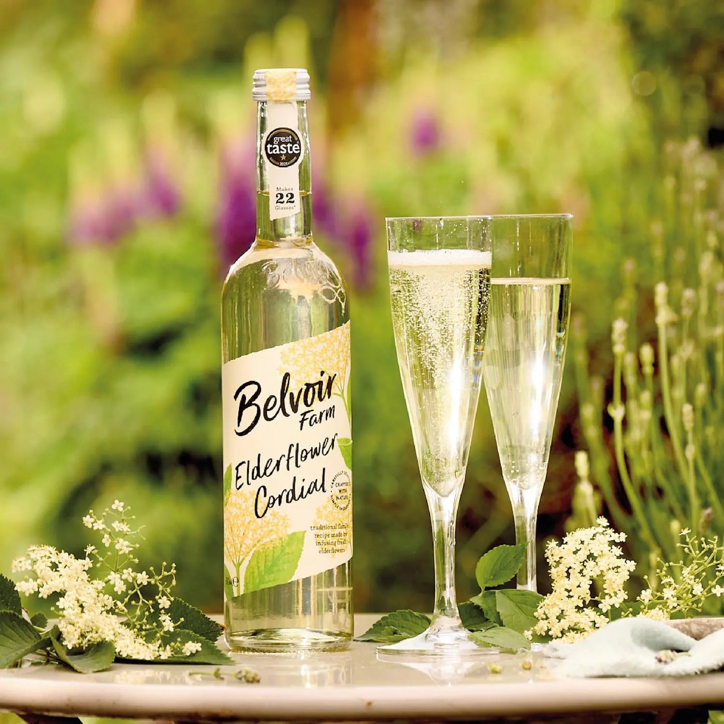 Belvoir Elderflower Cordial bottle with two glasses outdoors