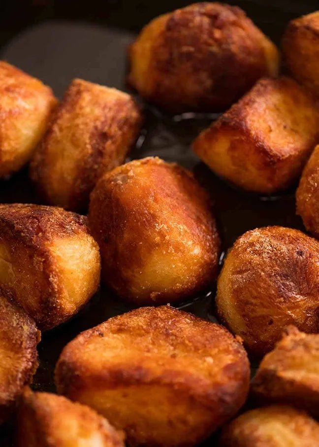 Close-up of roasted potatoes on a dark surface