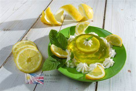 Lemon-flavored jelly dessert with whipped cream and lemon slices on a green plate.