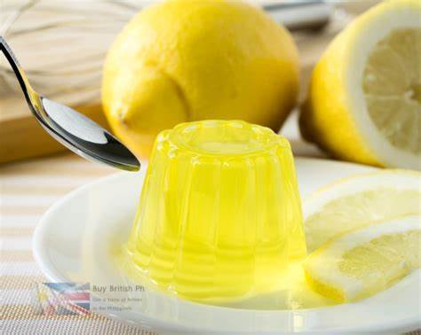 Yellow jelly dessert on a white plate with lemons in the background