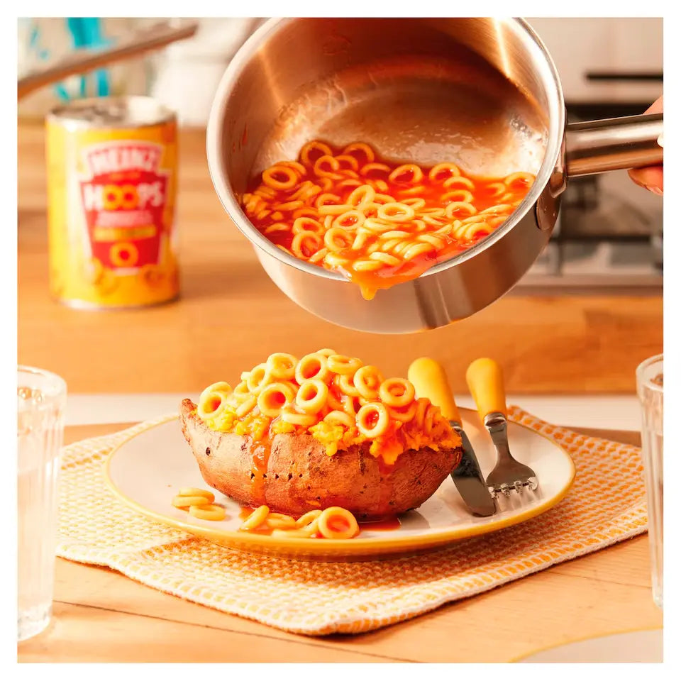 Pasta being poured from a pot onto a bowl on a kitchen counter.