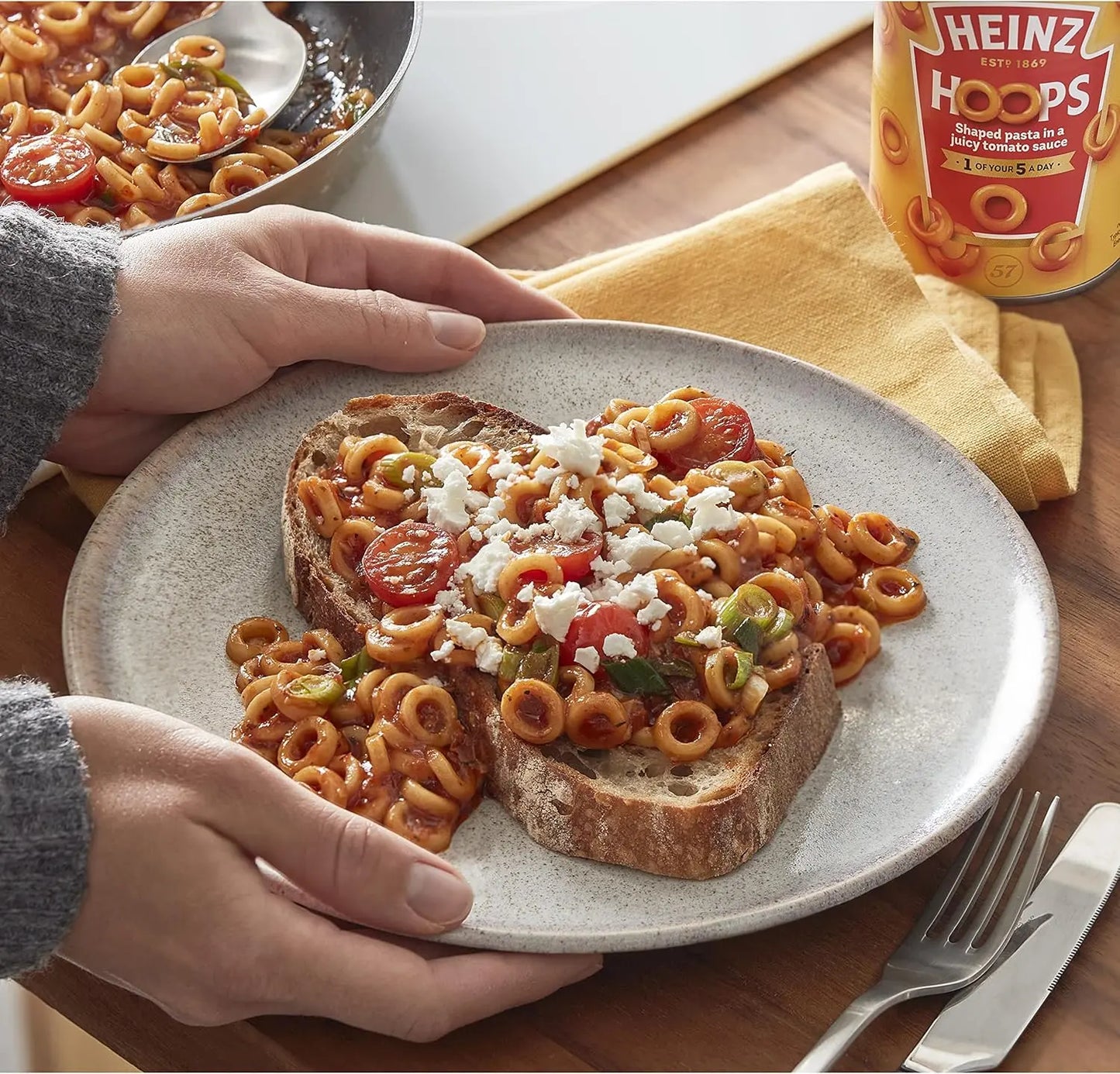 Plate of pasta on toast with Heinz Hoops can in the background