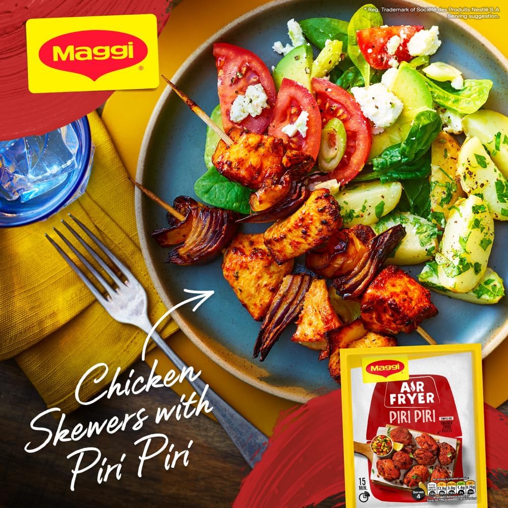 Plate of chicken skewers with piri piri seasoning, salad, and Maggi packaging on a wooden table.
