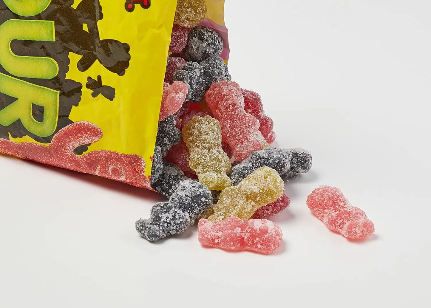 Colourful gummy candies spilling out of a bag with a white background