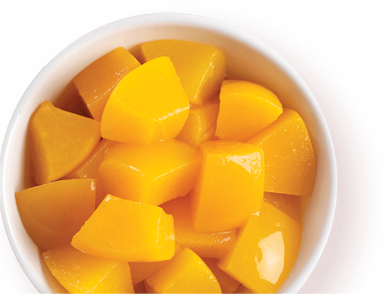 Cubed yellow fruit in a white bowl on a red background