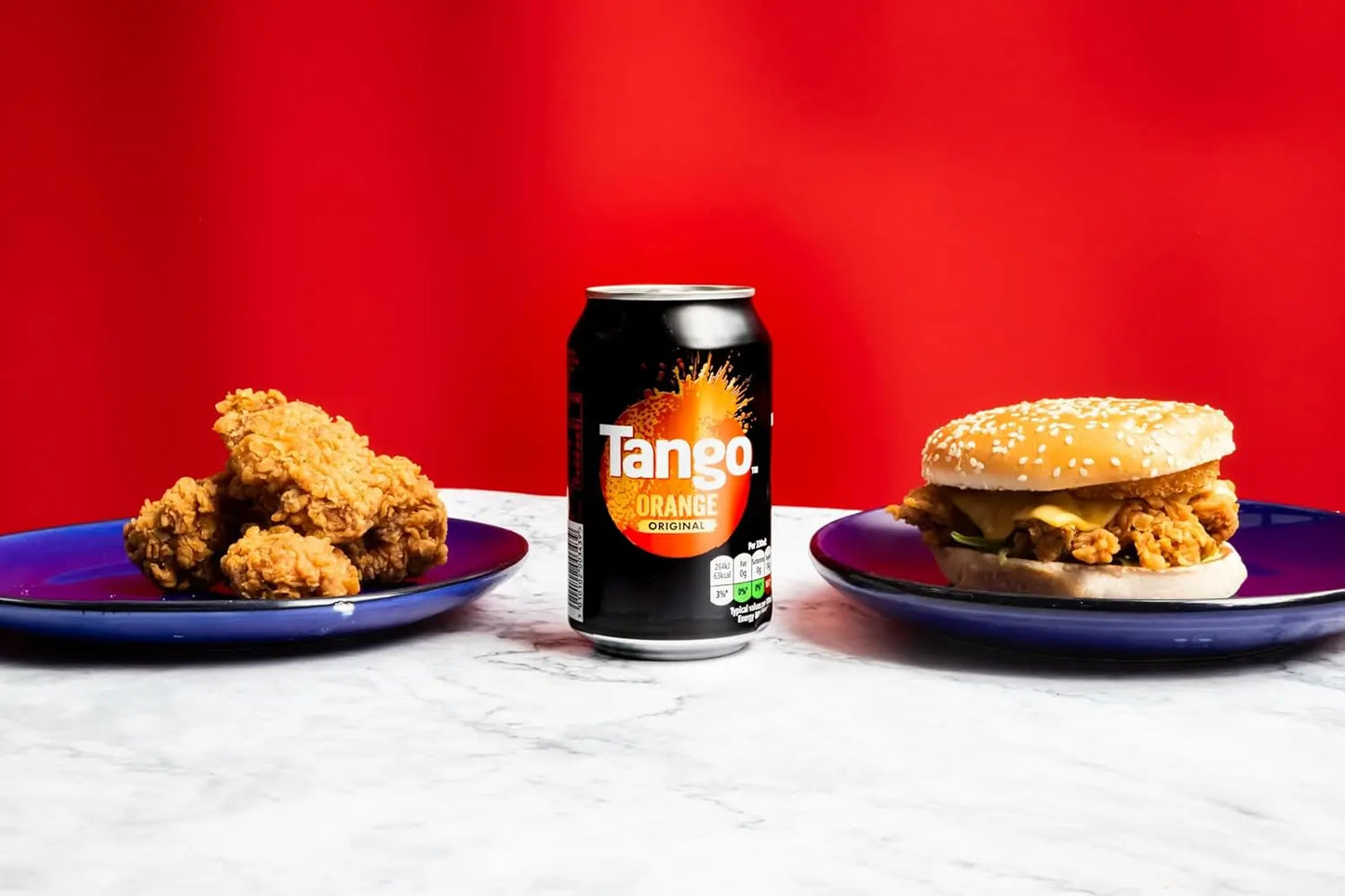 Tango Orange can with a burger and fried chicken on a red background