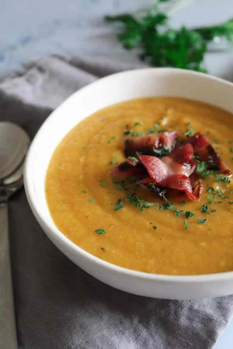 bowl of soup with garnish on a gray napkin