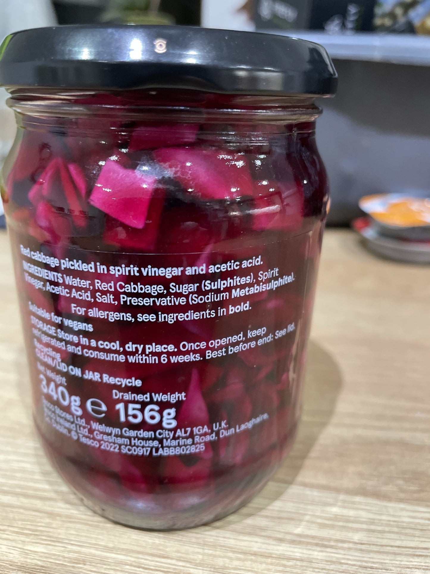 Jar of pickled red cabbage with label on a wooden surface