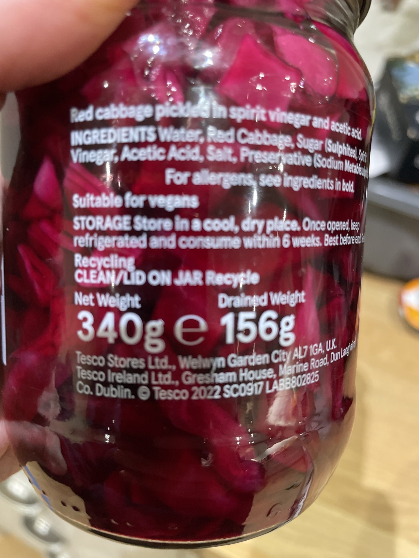 Close-up of a jar label with red cabbage pickles, showing ingredients and storage instructions.