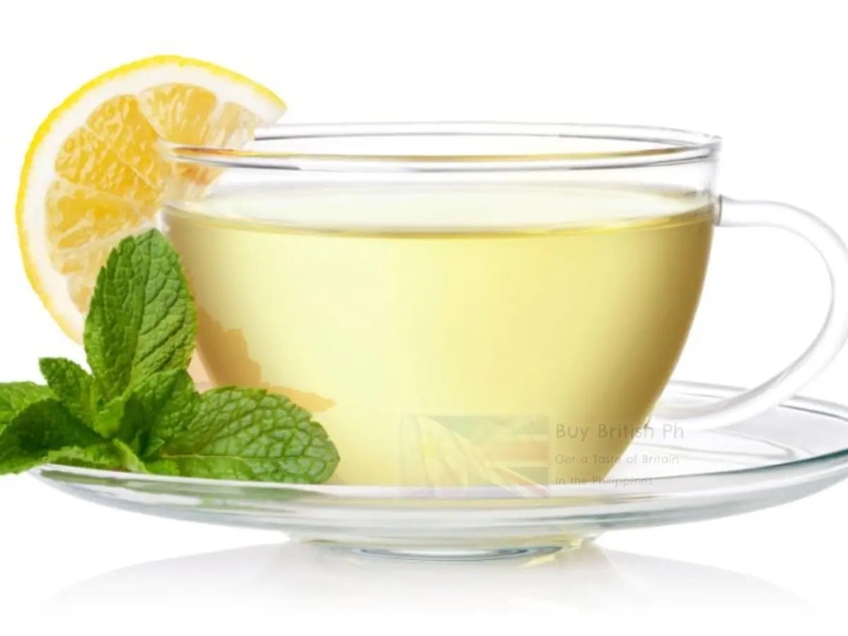 Clear glass cup of tea with lemon and mint leaves on a white background