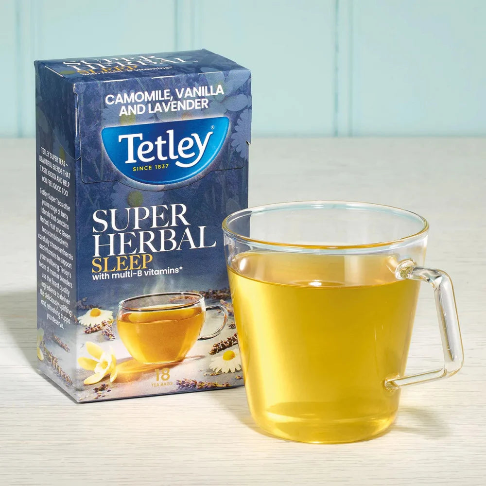 Tetley Super Herbal Sleep tea box with a glass of tea on a light surface.