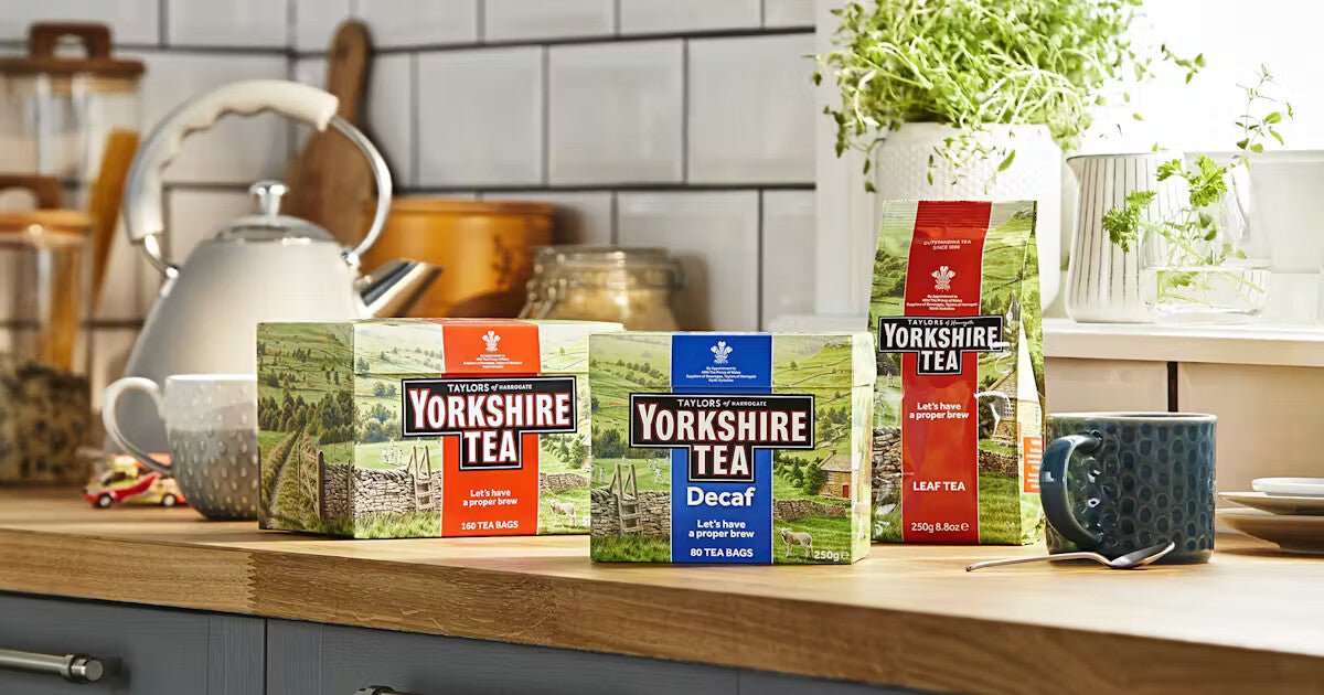 Yorkshire Tea packages on a kitchen counter with a teapot and mugs.