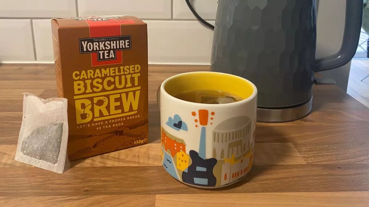 Yorkshire Tea Caramelised Biscuit Brew box with a mug and kettle on a wooden surface