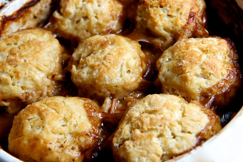 Baked dumplings in a casserole dish with a brown sauce