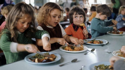 British school children eating traditional school dinner in UK cafeteria