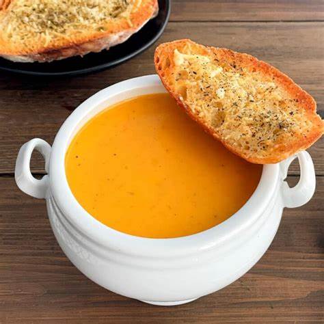 British tomato soup served in a bowl with bread