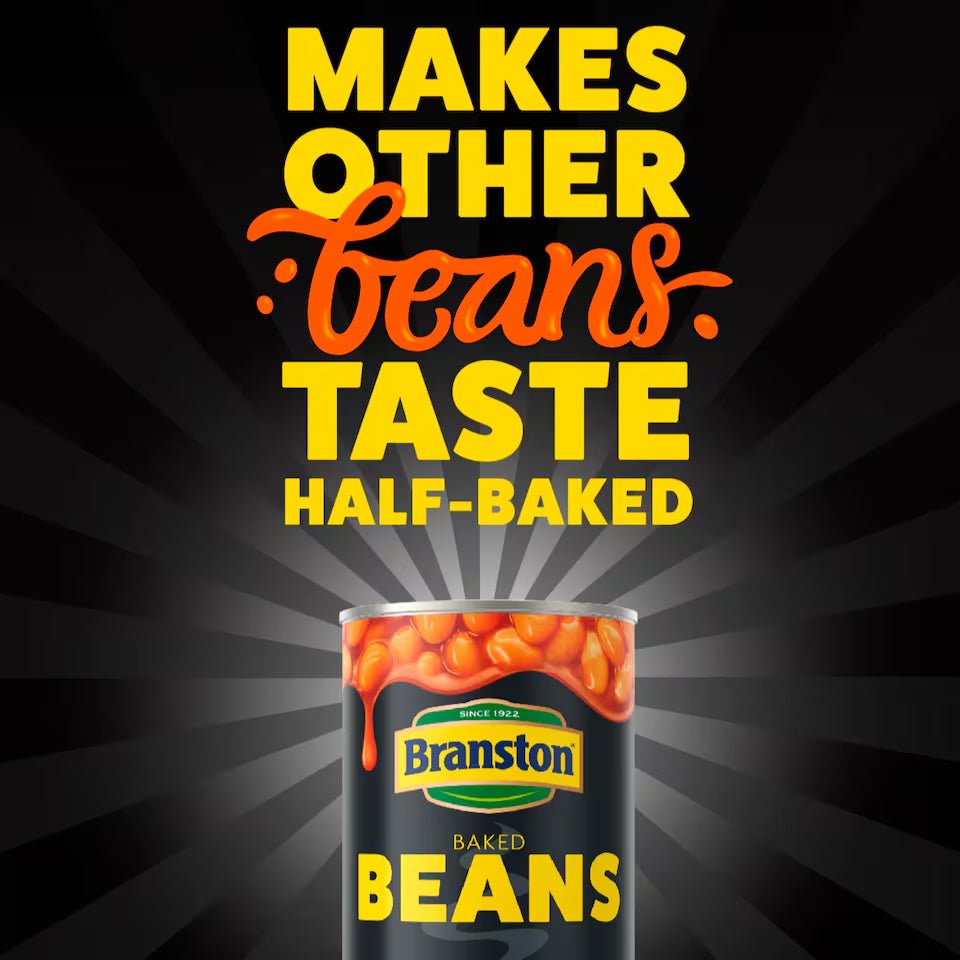 Can of Branston baked beans with promotional text on a dark background