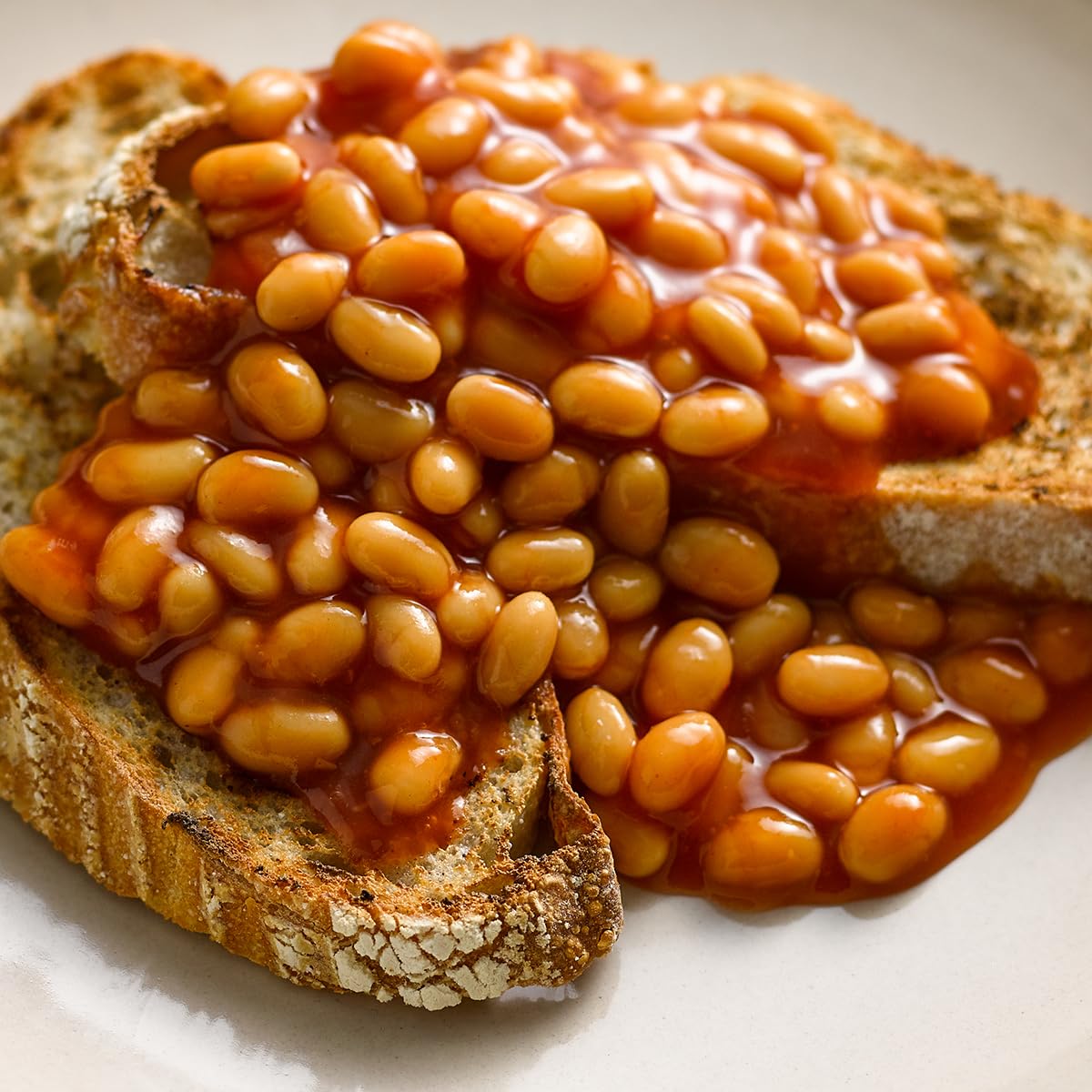 Baked beans on toast on a white plate