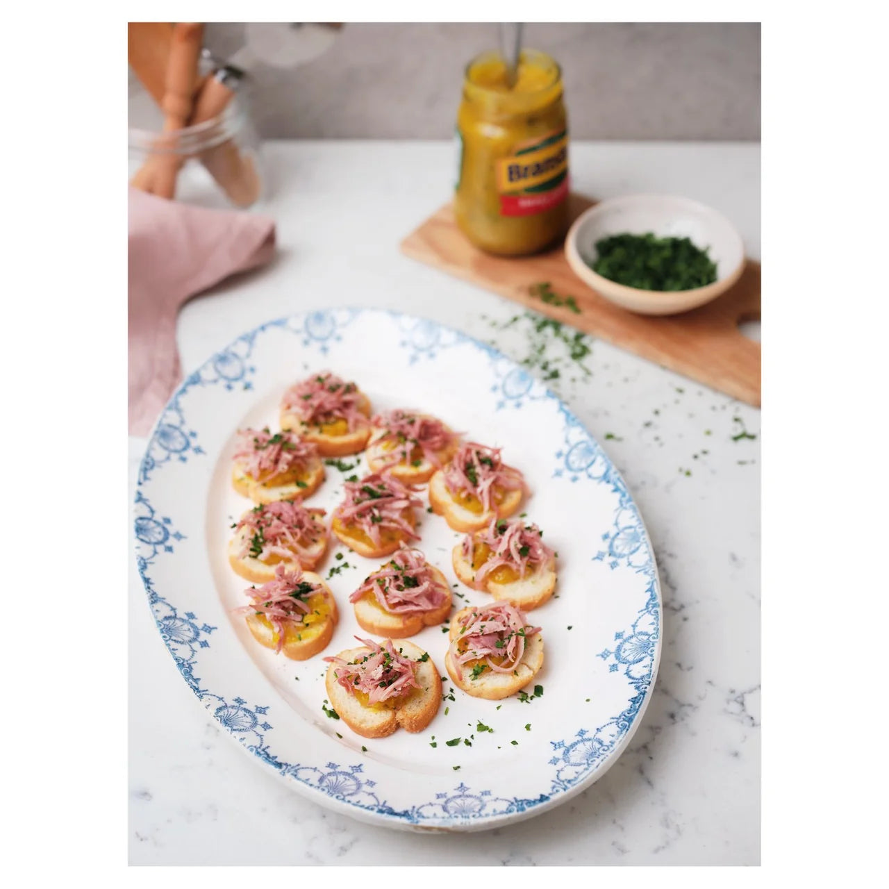 Platter of canapés with a jar of mustard on a marble surface