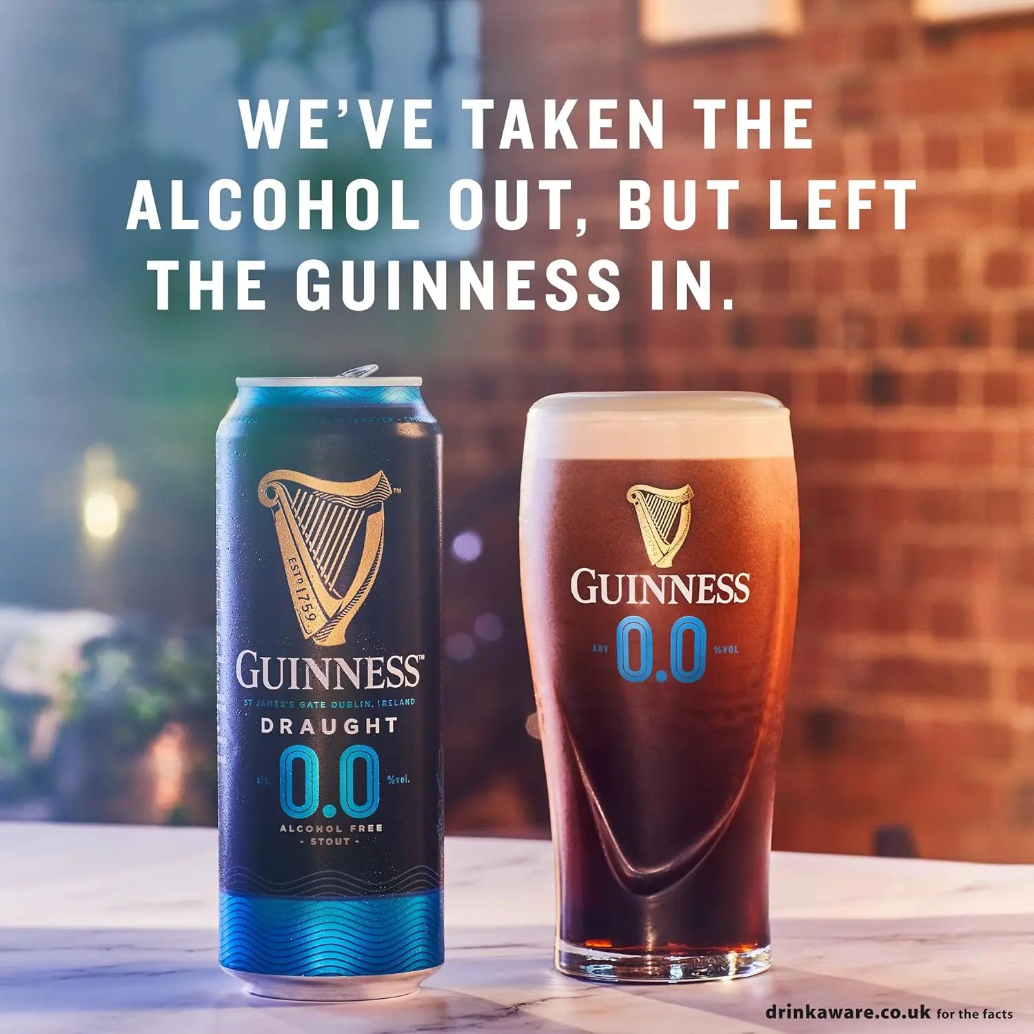 Guinness Draught 0.0 can and glass on a table with a blurred background