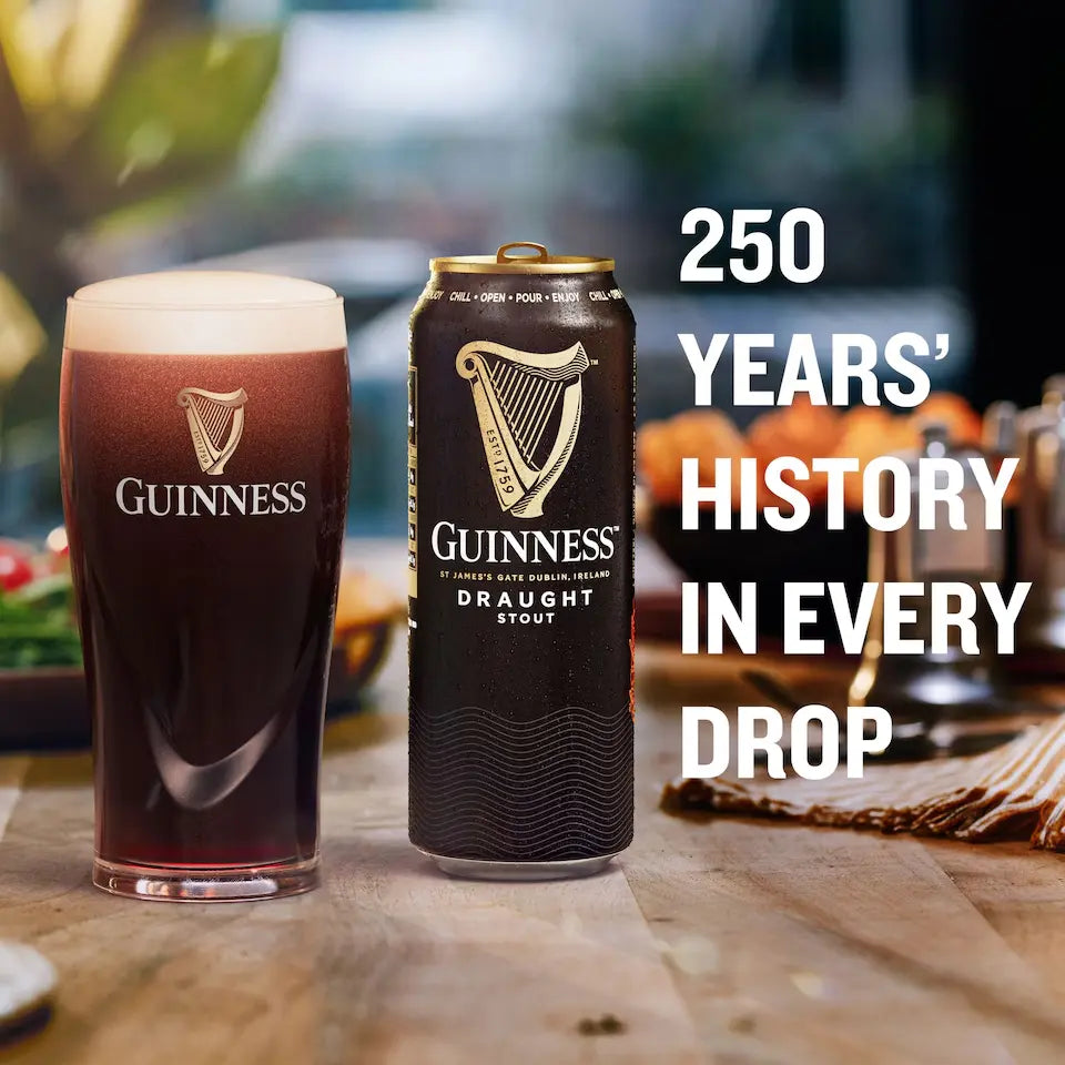 Guinness draught stout glass and can on a wooden table with blurred background