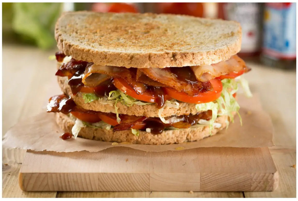 Delicious sandwich with multiple layers of ingredients on a wooden board.