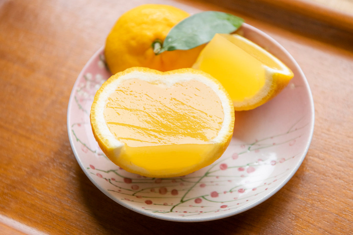 Sliced lemon on a decorative plate with a wooden background
