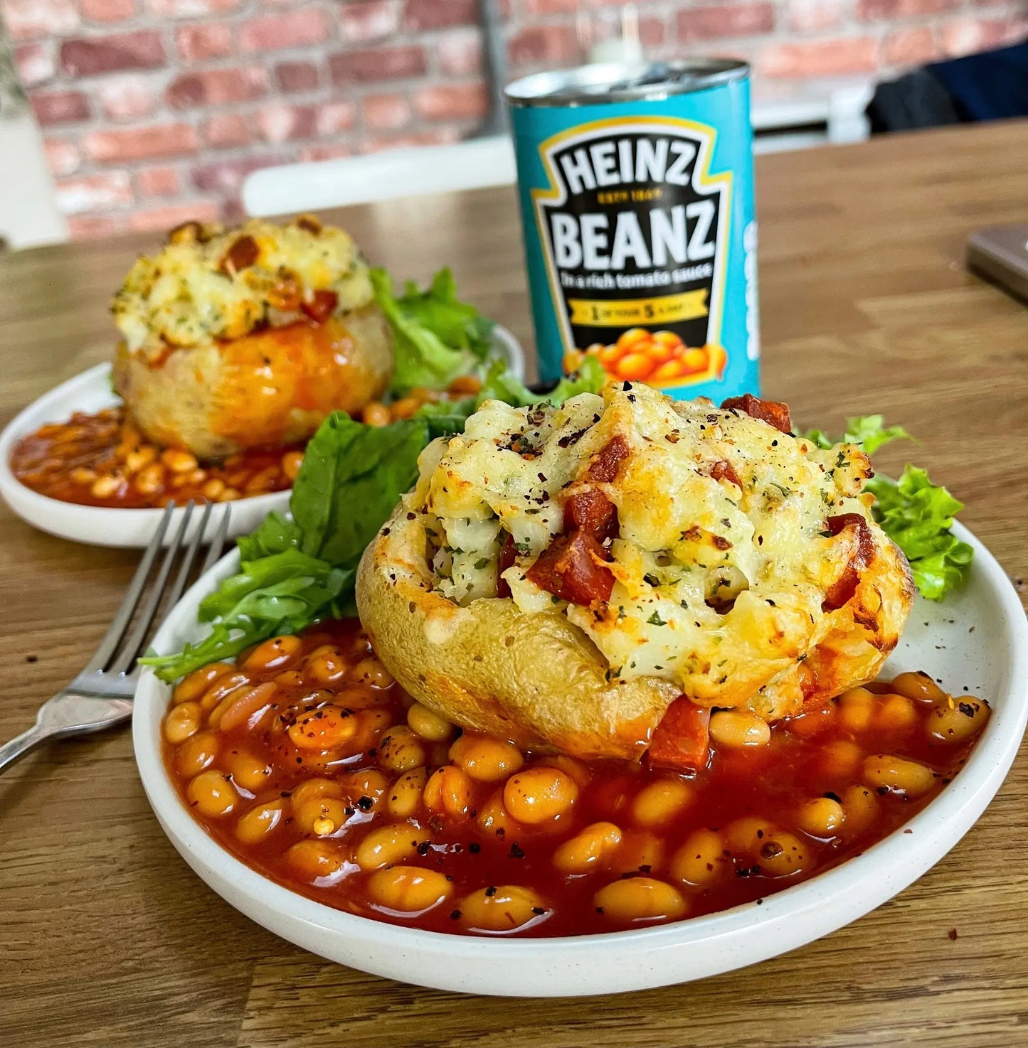 Heinz Baked Beans in a Rich Tomato Sauce 415g tin in the Background with Cheese and Baked Potato