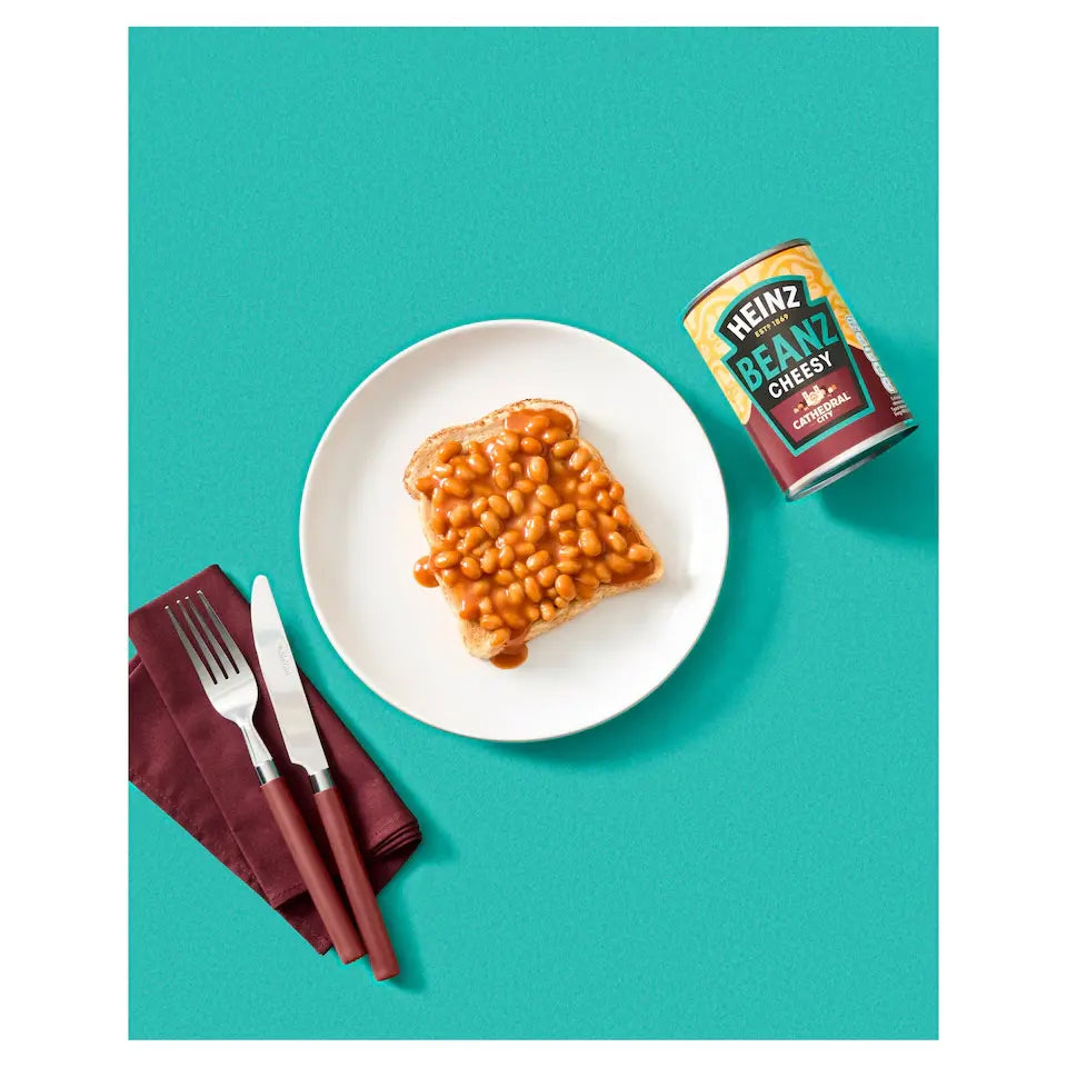 Plate of baked beans with a can of Heinz Baked Beans on a teal background