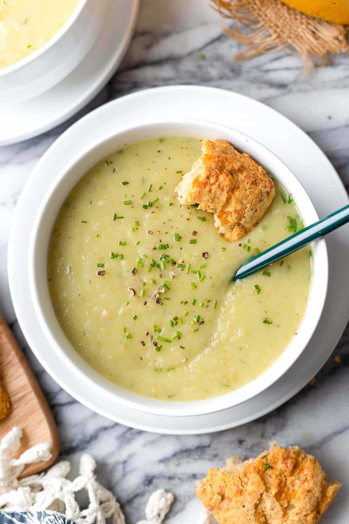 Bowl of soup with a spoon and crouton on a marble surface