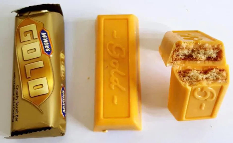 Gold-wrapped candy bar with packaging and a single piece on a white background