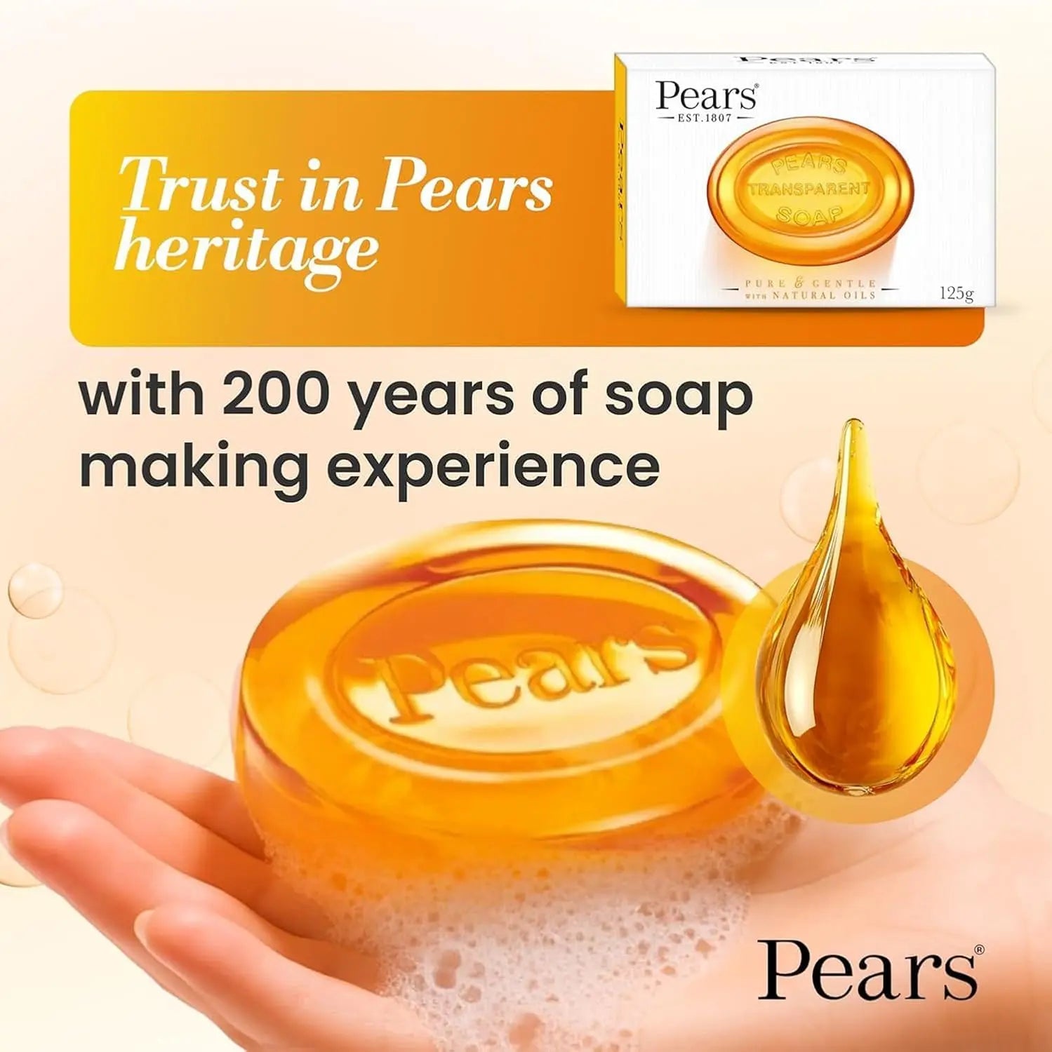 Pears soap bar with a drop of oil on a hand, branded packaging in the corner, and text about heritage and soap making experience.