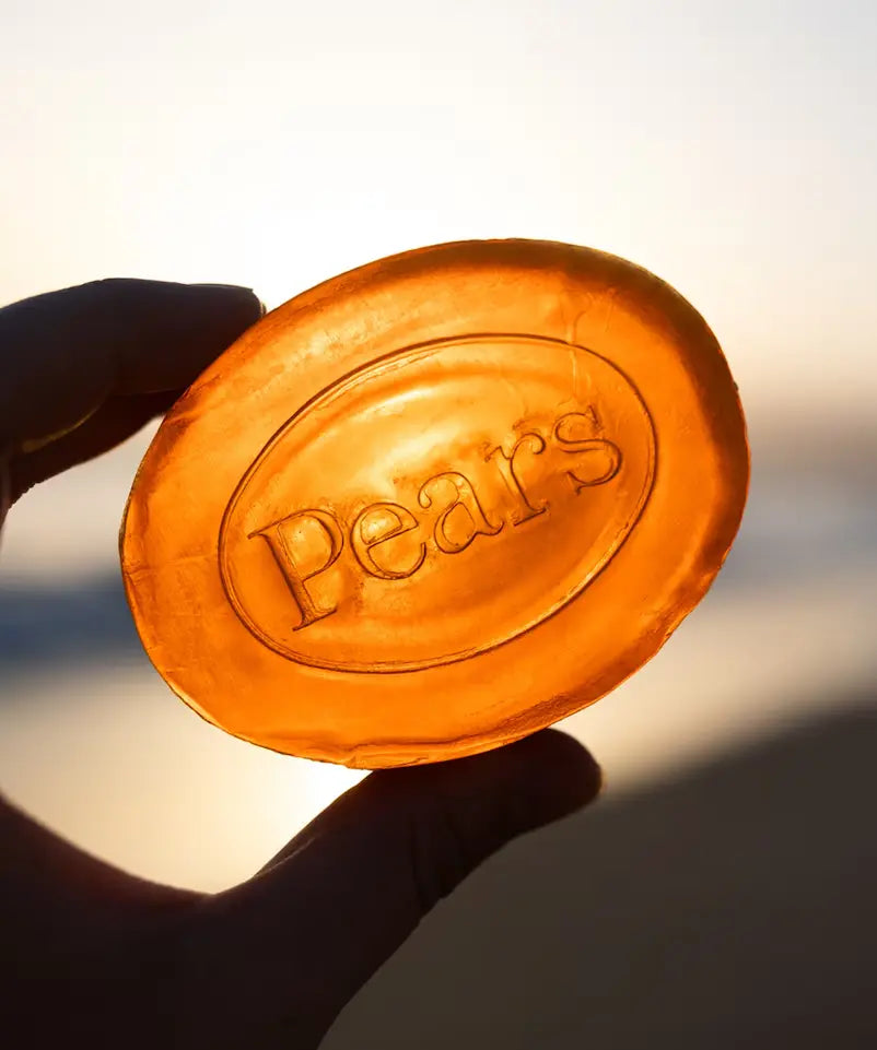 Orange Pears soap bar held against a blurred background