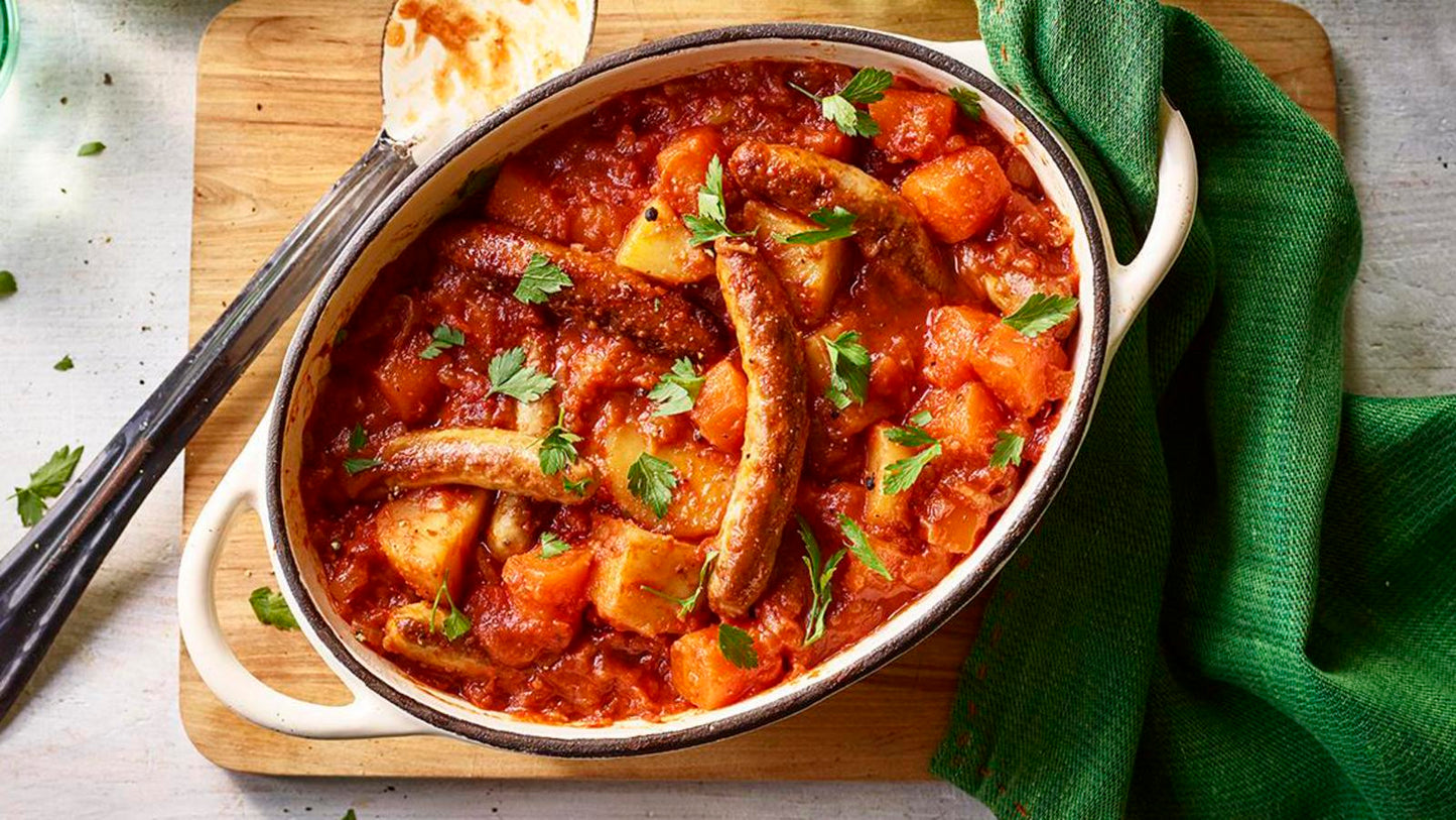 Stew with vegetables in a bowl on a wooden cutting board