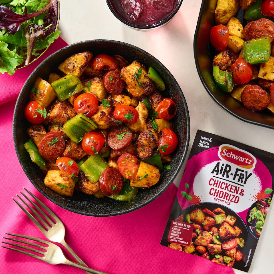 Bowl of chicken and chorizo dish with a package of Schwartz Air-Fry Chicken & Chorizo mix on a pink and white background.