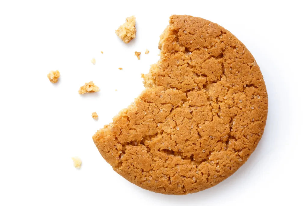 Ginger Nut Biscuit with a bite taken out of it on a white background