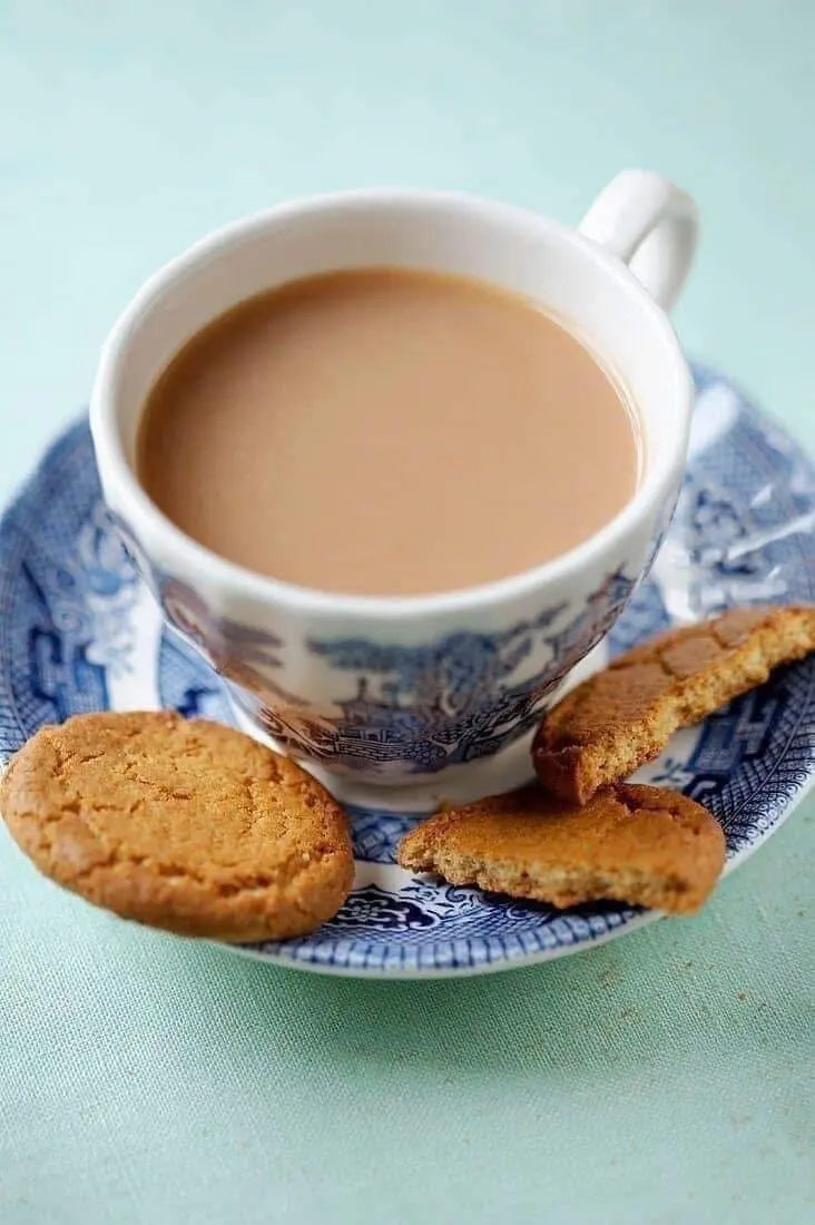 Cup of tea with Ginger Nut Biscuit on a decorative plate