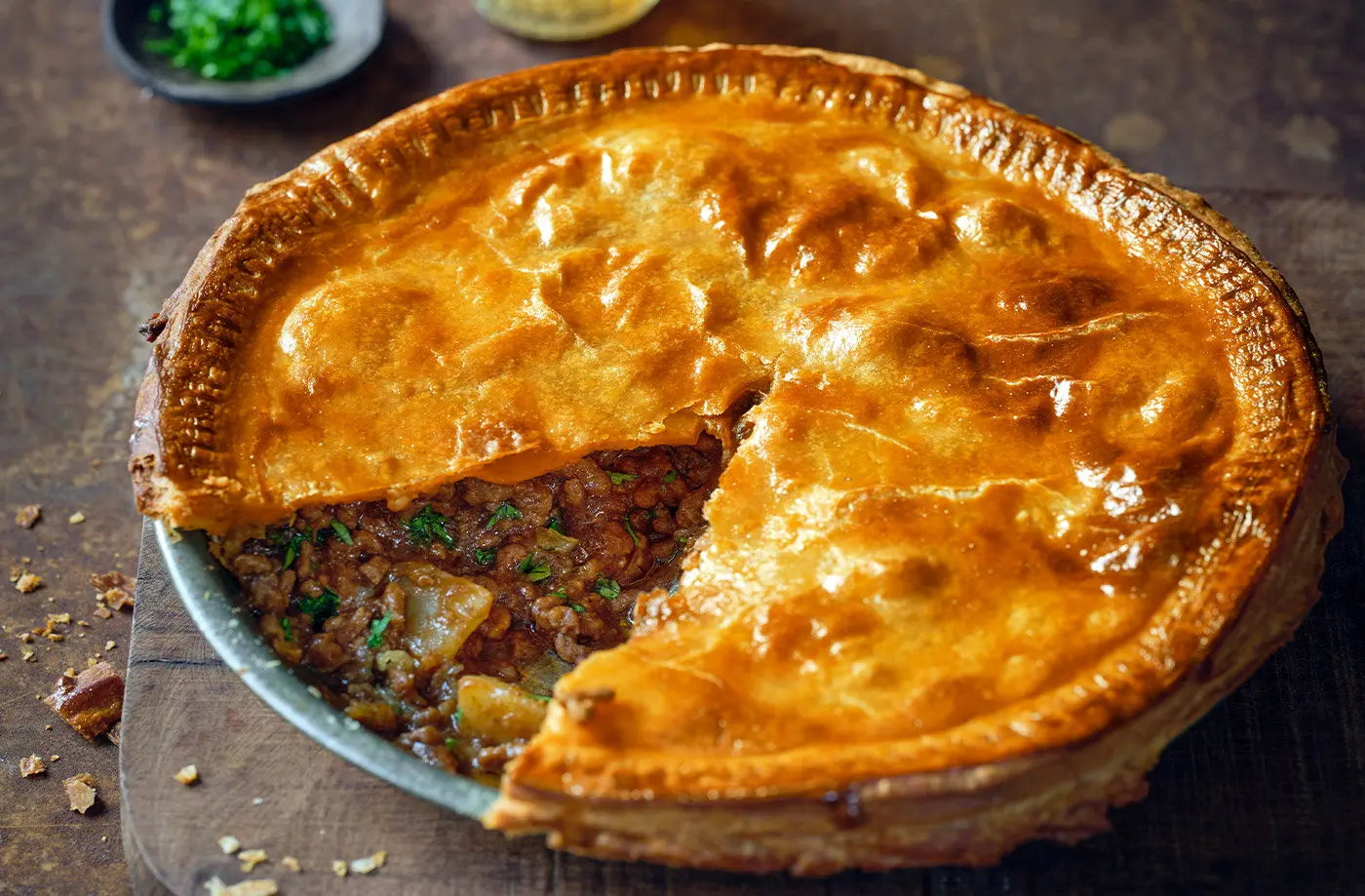 Shepherd's pie with a slice cut out on a wooden board