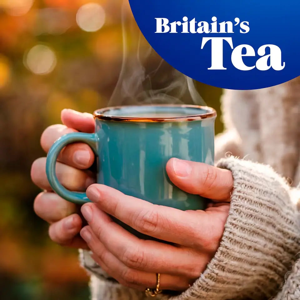Person holding a steaming blue mug with 'Britain's Tea' logo in the corner