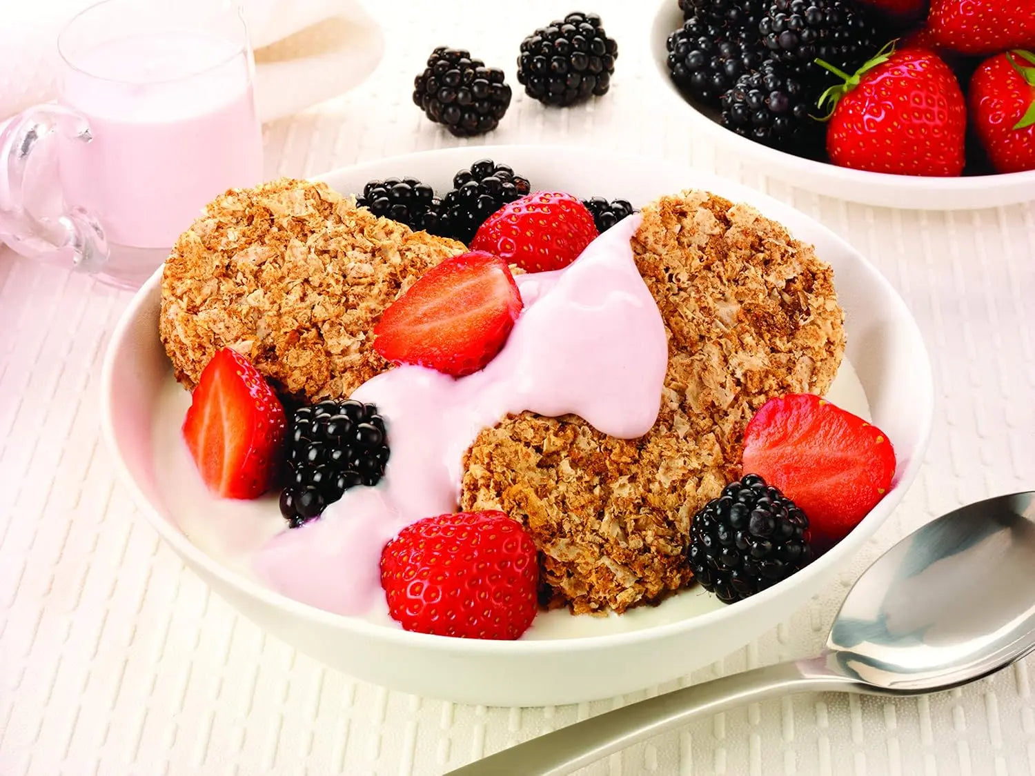 Yogurt with heart-shaped cookies and berries on a white plate