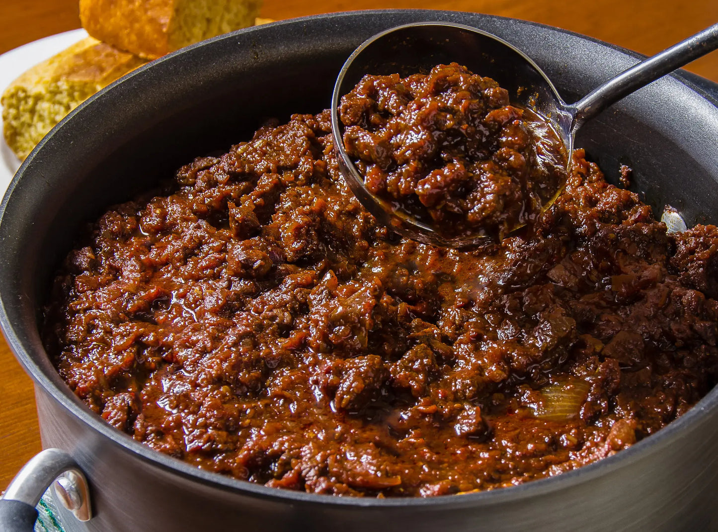 Stir-fried meat dish in a pan with a spoon